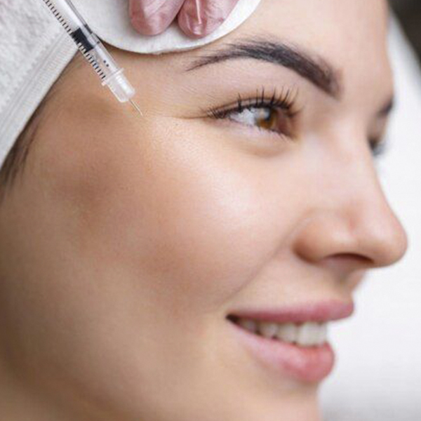 Premium Photo _ Close up of hands of young cosmetologist injecting botox in female face She is standing and smiling The woman is closed her eyes with relaxation